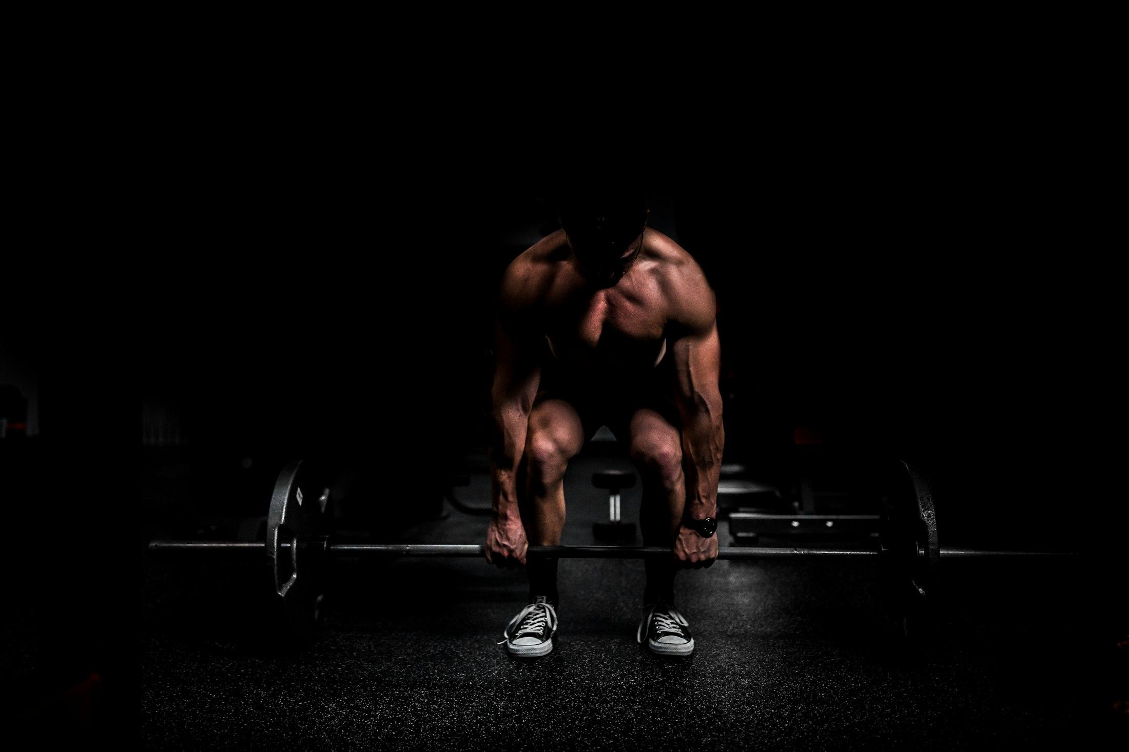 An athlete gripping a loaded barbell for a deadlift
