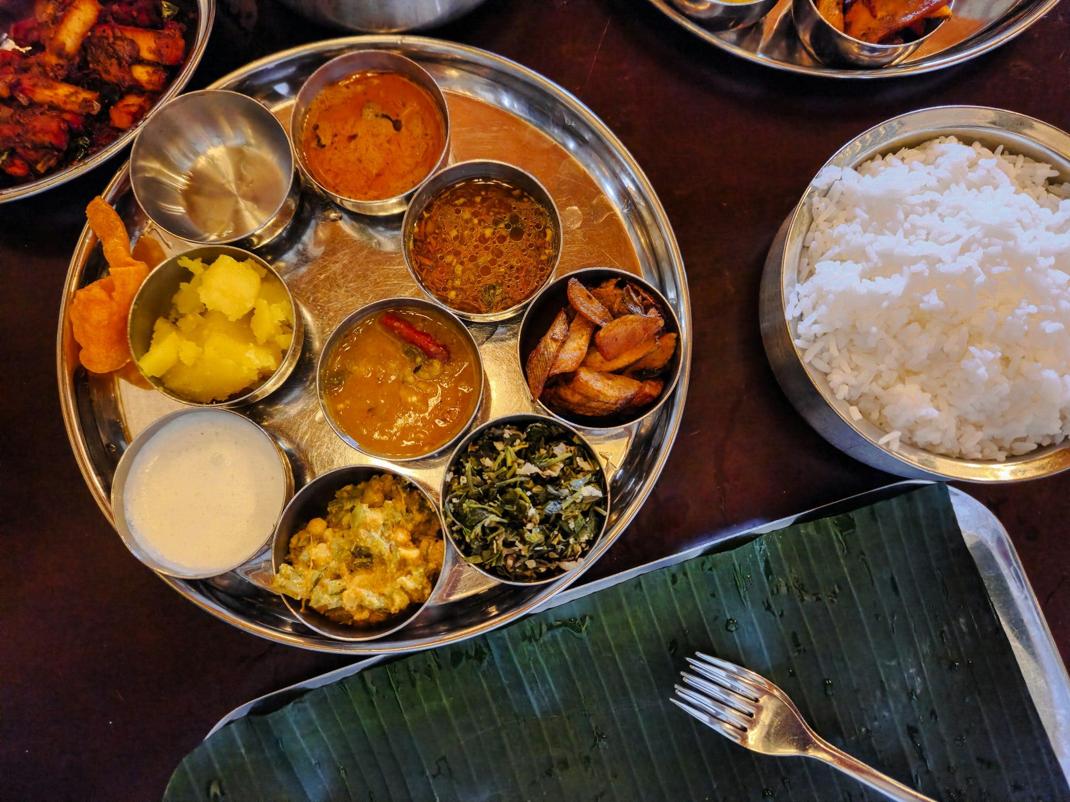 A home-style thali with rice, dal, sambar, sabzi and curd, photographed from above